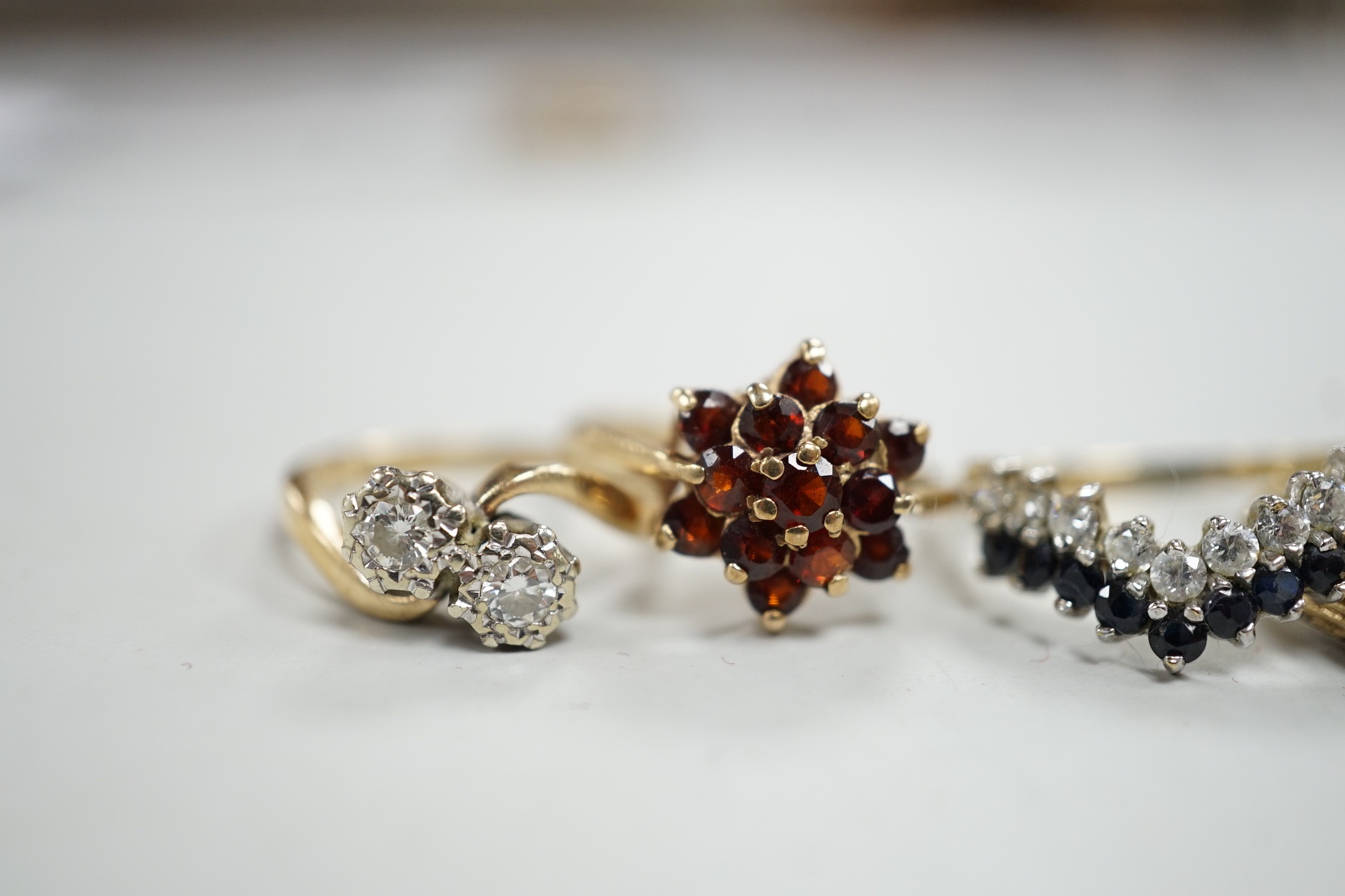 Four assorted modern 9ct gold and gem set rings, including a two stone diamond crossover, size K/L, gross 8.5 grams.